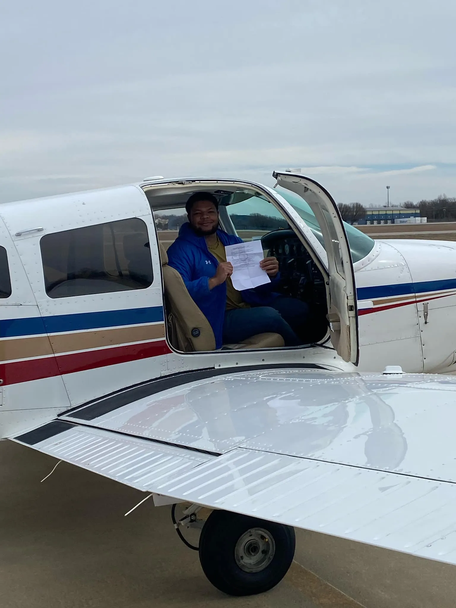 Certified flight instructor and student pilot checking engine cowl during discovery flight preflight