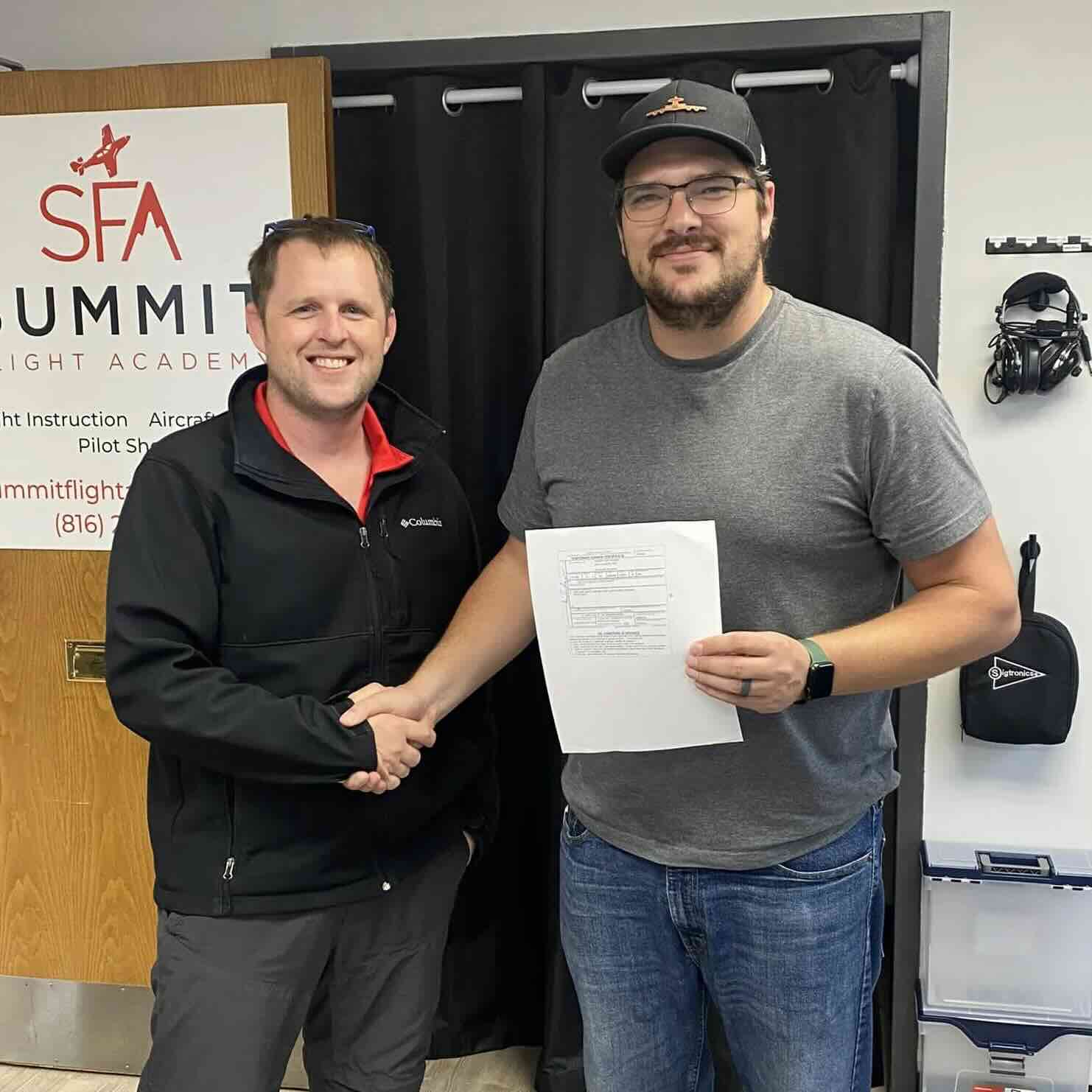 Certified flight instructor and student holding a multi-engine rating certificate after completing training at Summit Flight Academy