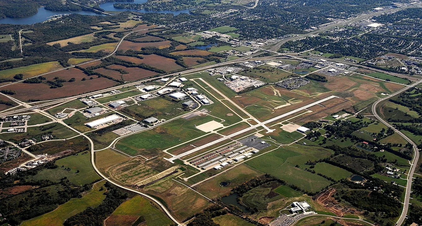 aerial view of airport runway with planes parked on the side