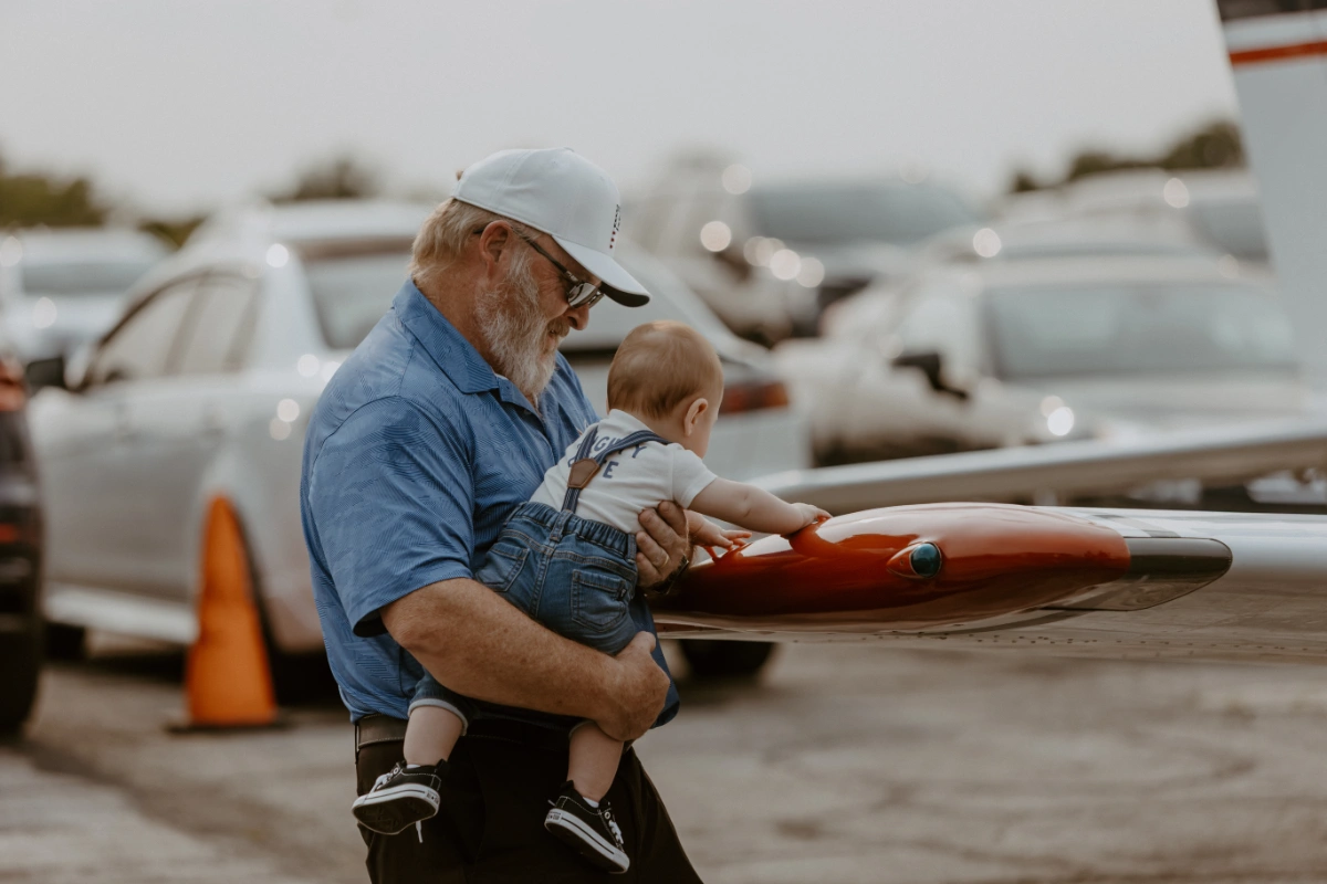 Summit Flight Academy's new hangar groundbreaking ceremony at Lee's Summit Airport, featuring a group of people with shovels and aircraft in the background.