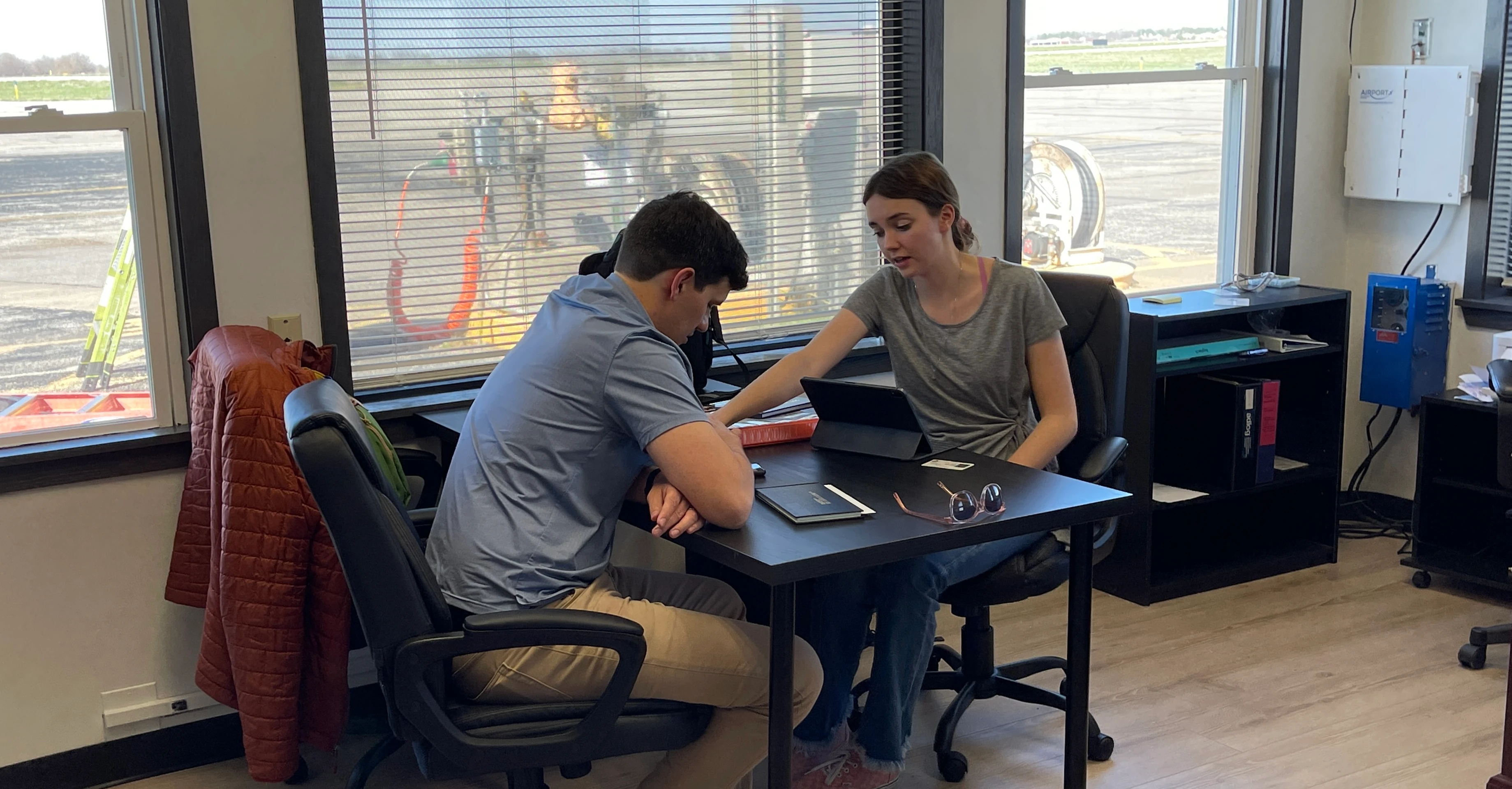 Student pilot reviewing a lesson with a flight instructor next to the ramp at Lee's Summit airport