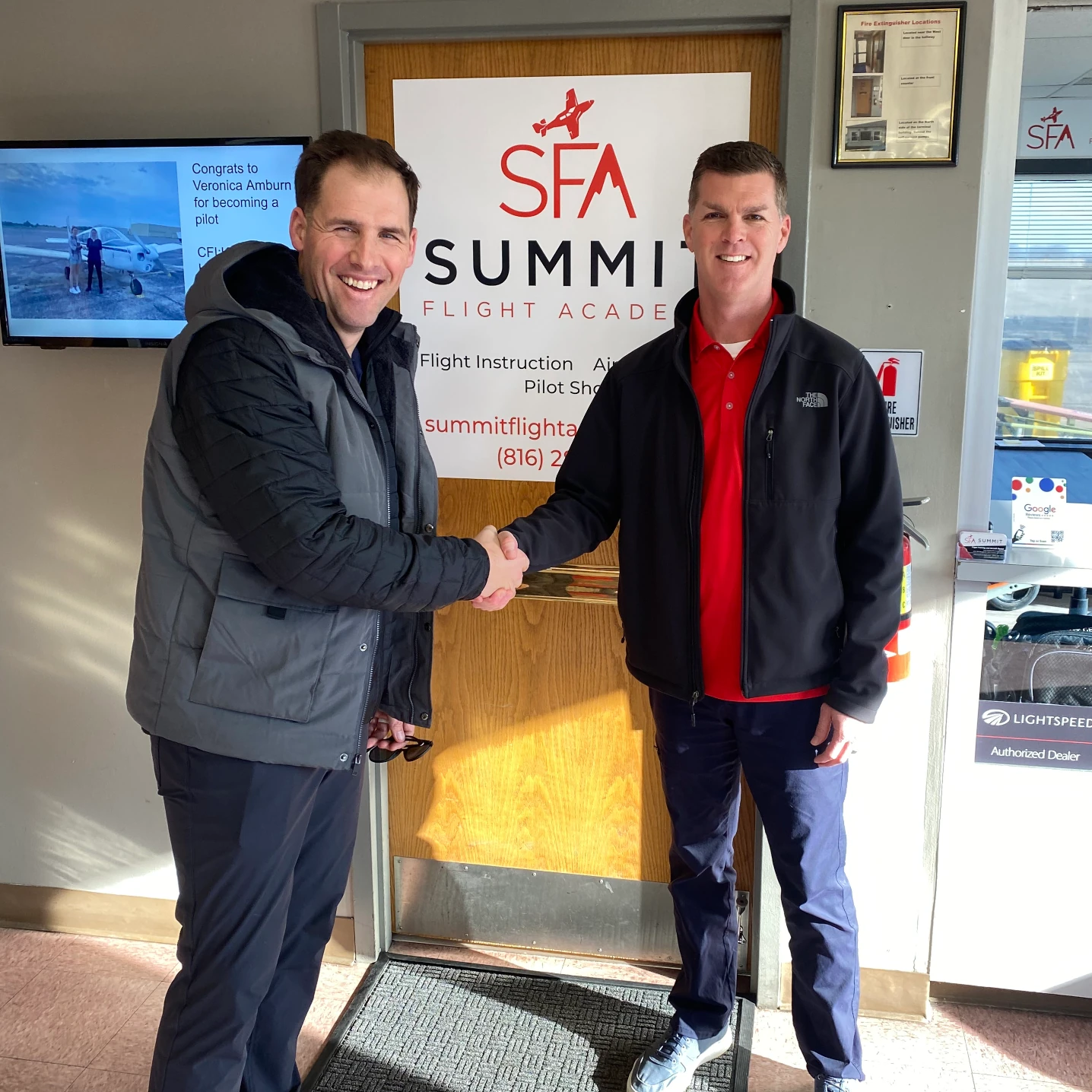 Certified Flight Instructor and student shaking hands at Summit Flight Academy's office