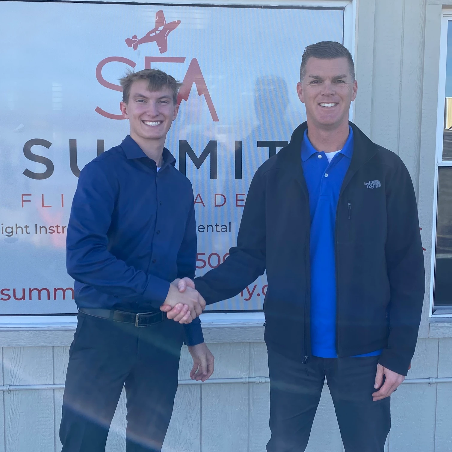 Certified Flight Instructor and student shaking hands while smiling at the camera