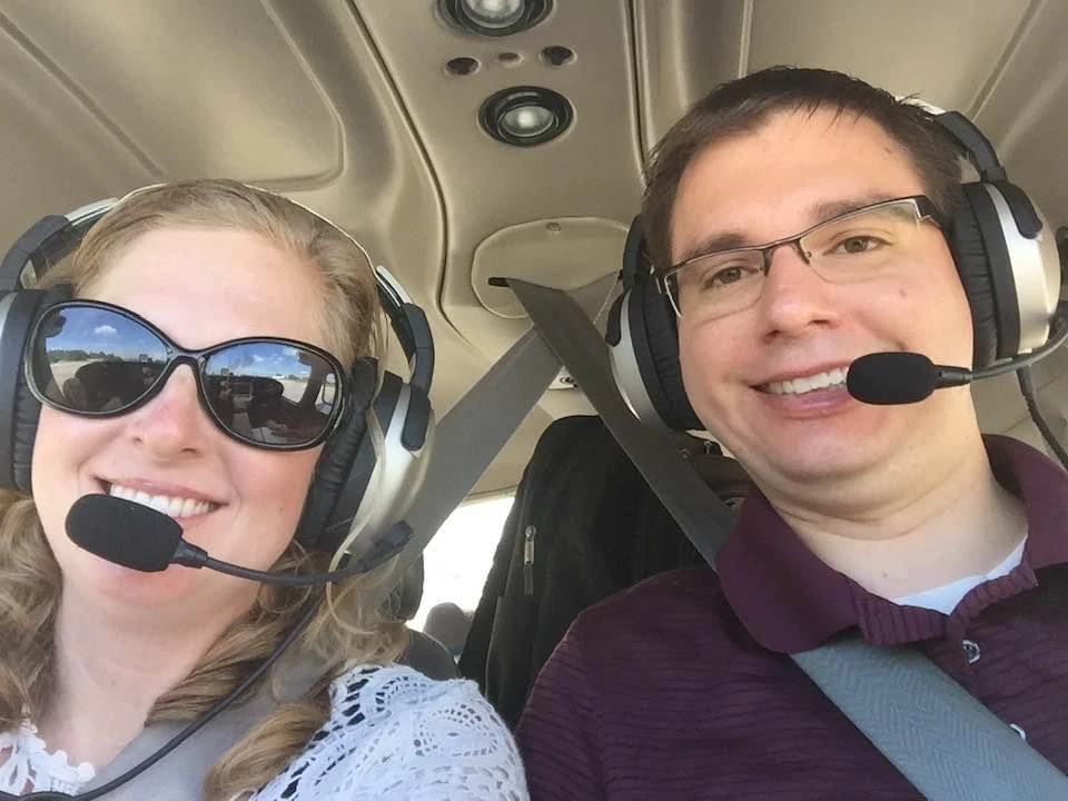 CFI and student smilling to the camera while flying over Kansas City