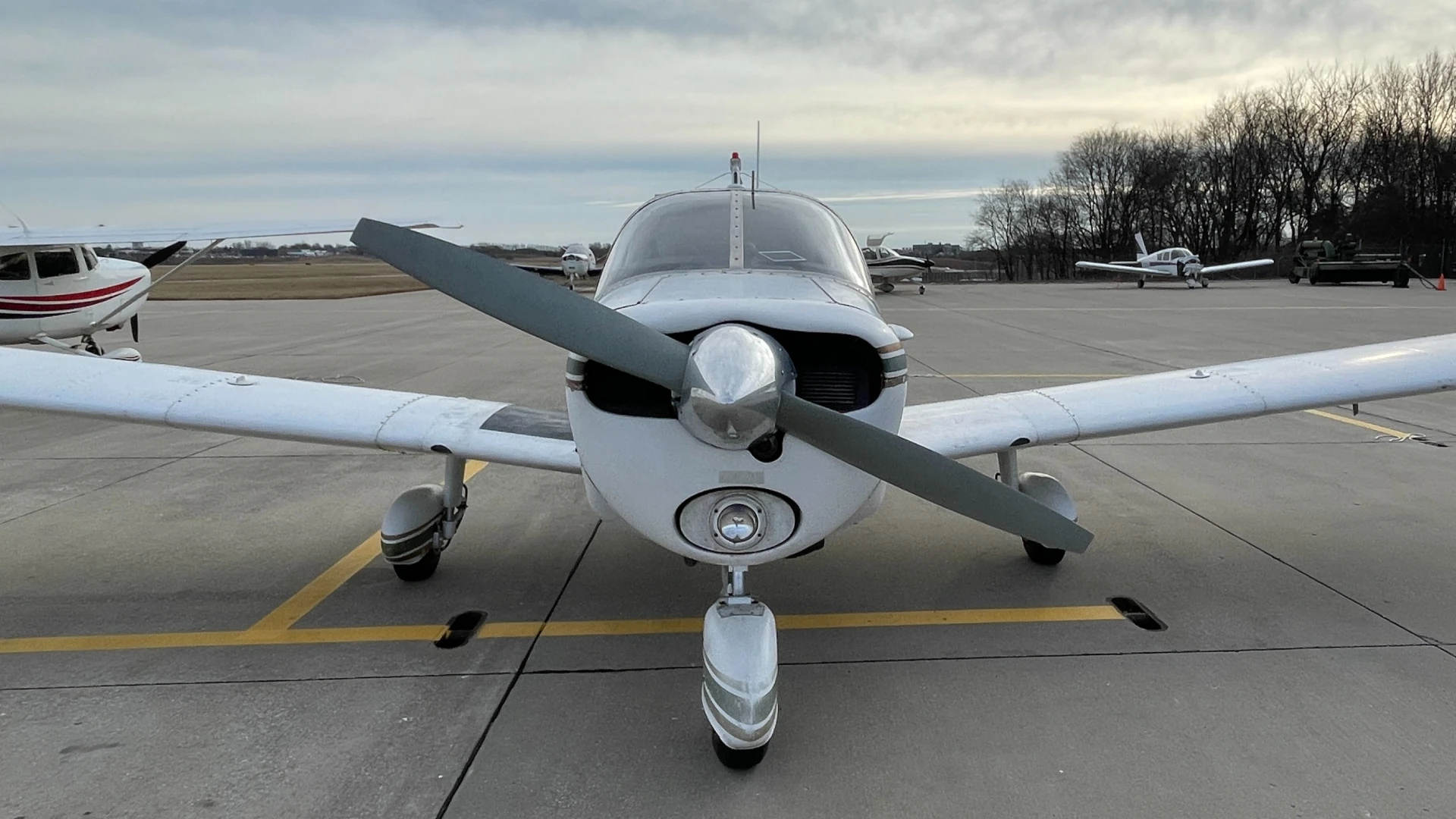 Front view of a Piper Cherokee parked on the runway