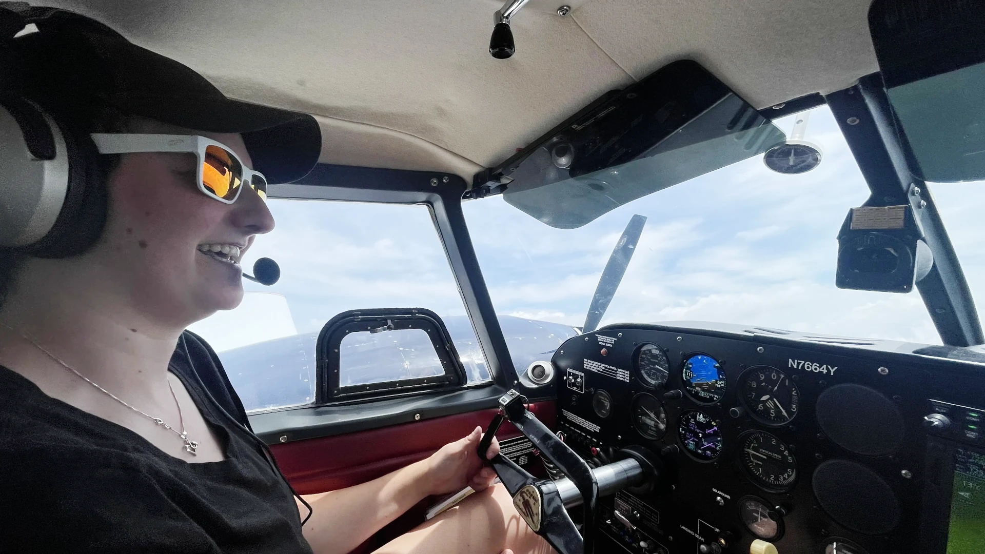 View from inside of the cockpit of a pilot flying the aircraft while smiling