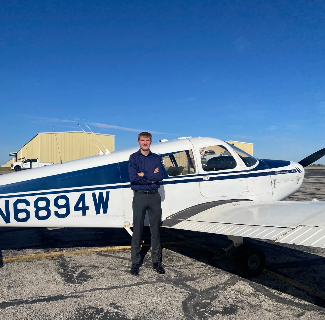 Student pilot standing in front of a Piper Cherokee at Lee's Summit Airport before a training flight