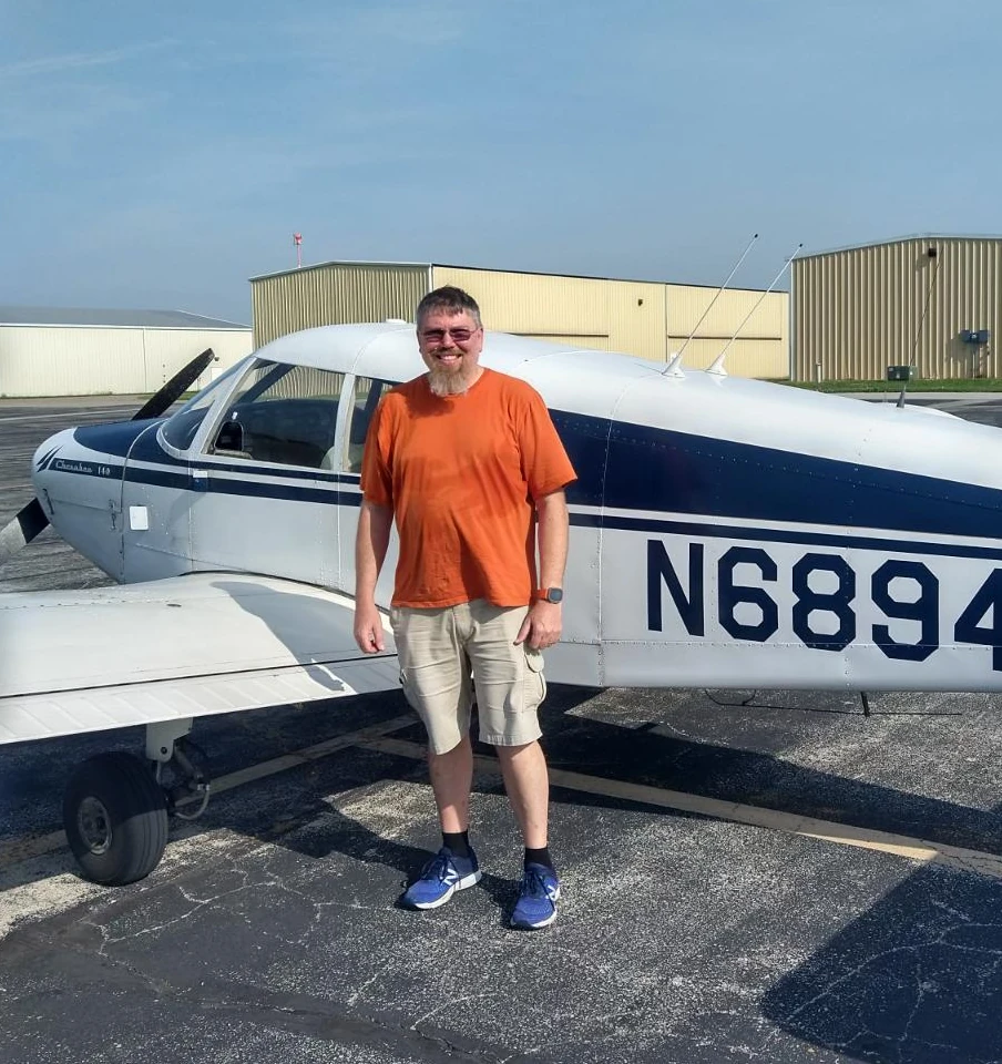 summit-flight-academy-very-happy-pilot-stanging-next-to-piper-cherokee-instrument-rating